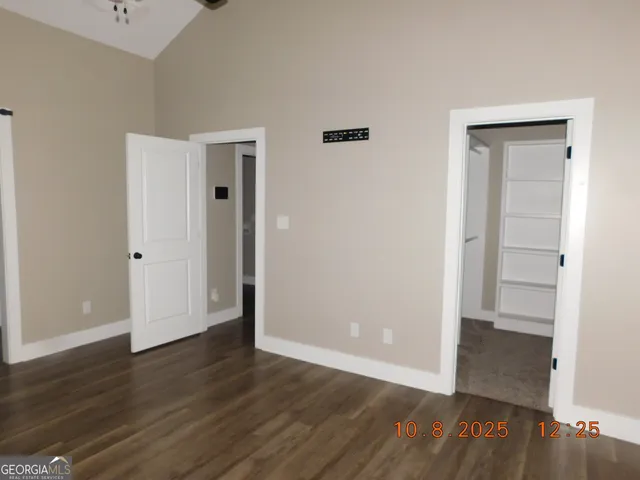 an empty room with wooden floor & closet area