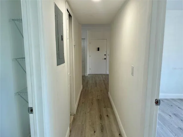 a view of a hallway with wooden floor and staircase