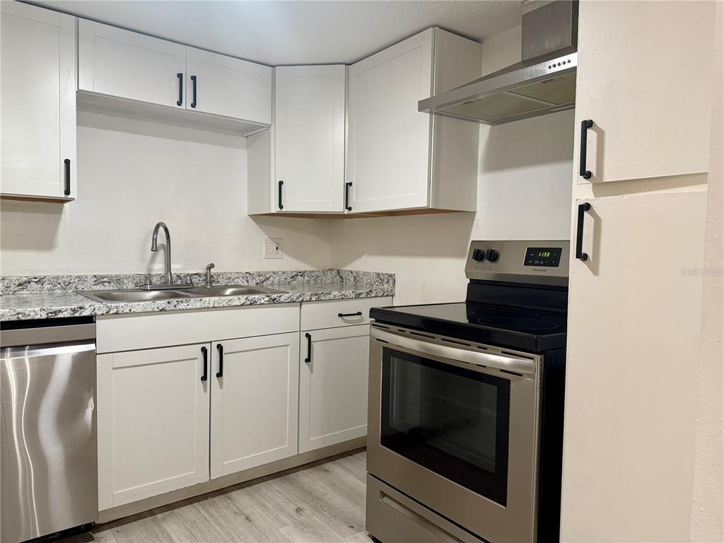 900 North Lake Destiny Road, Unit A Altamonte Springs, FL 32714 - Photo 2 of 26 a kitchen with granite countertop white cabinets white stainless steel appliances and sink