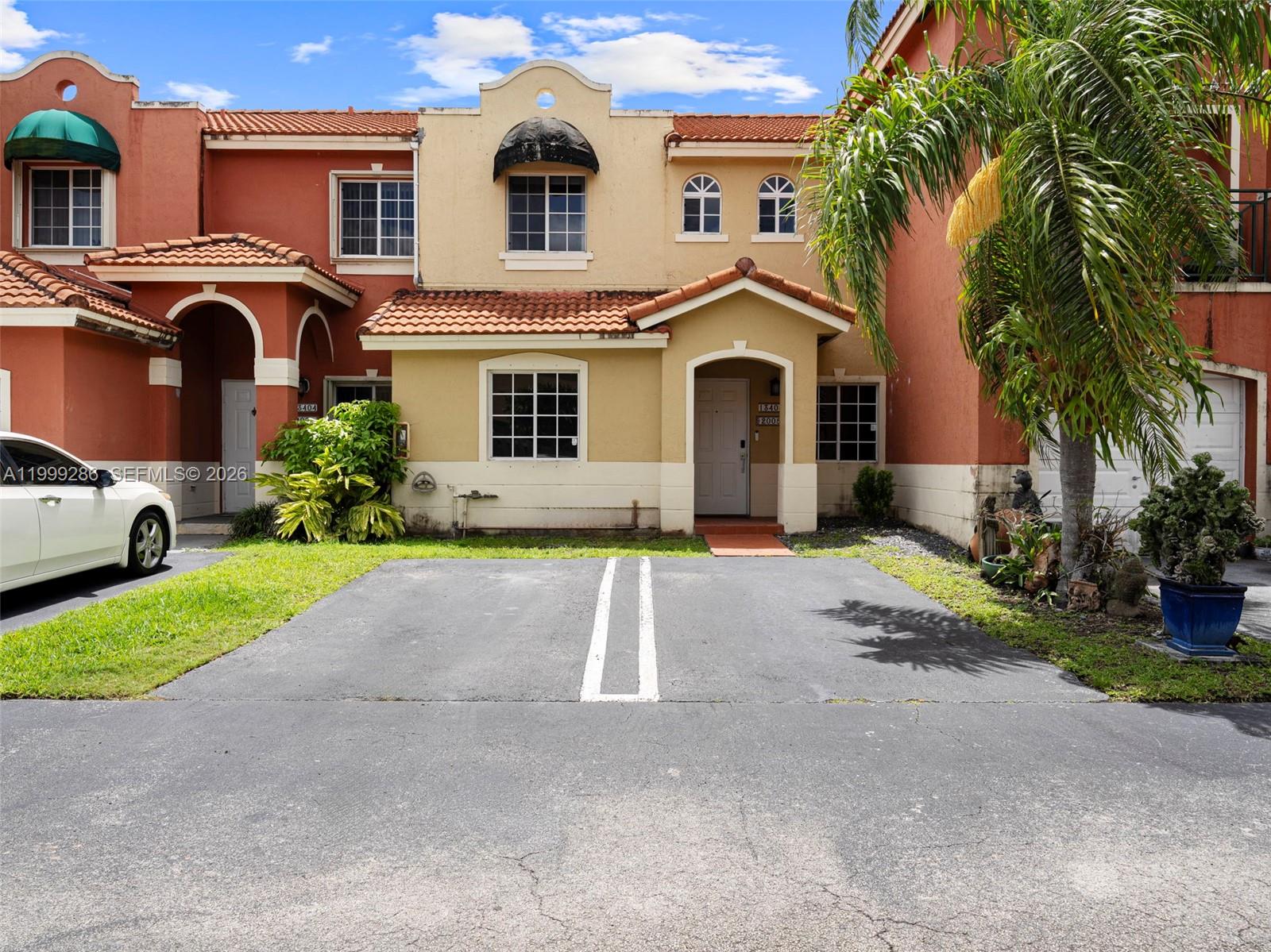 13404 Southwest 153 Terrace, Unit 2005 Miami, FL 33177 - Photo 2 of 49 a front view of a house with a yard and garage