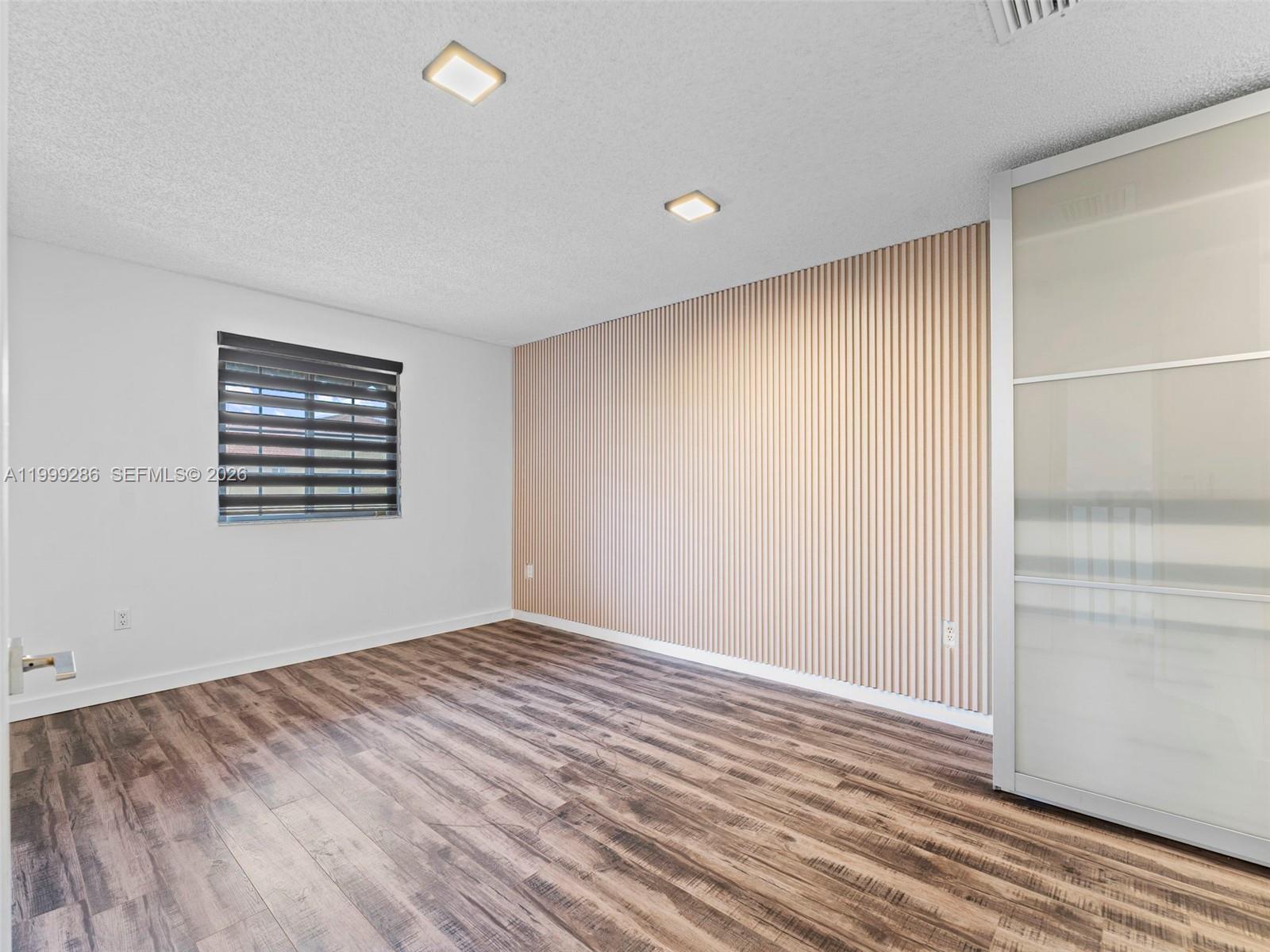 13404 Southwest 153 Terrace, Unit 2005 Miami, FL 33177 - Photo 33 of 49 wooden floor in an empty room with a window