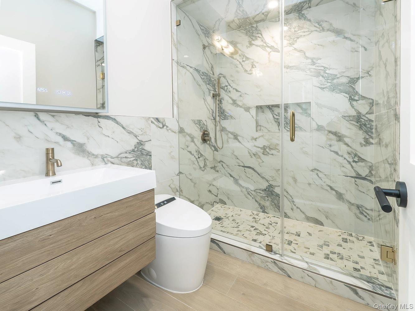 24 Lumber Road, Unit 1 Roslyn, NY 11576 - Photo 17 of 18 a bathroom with a sink a toilet and shower