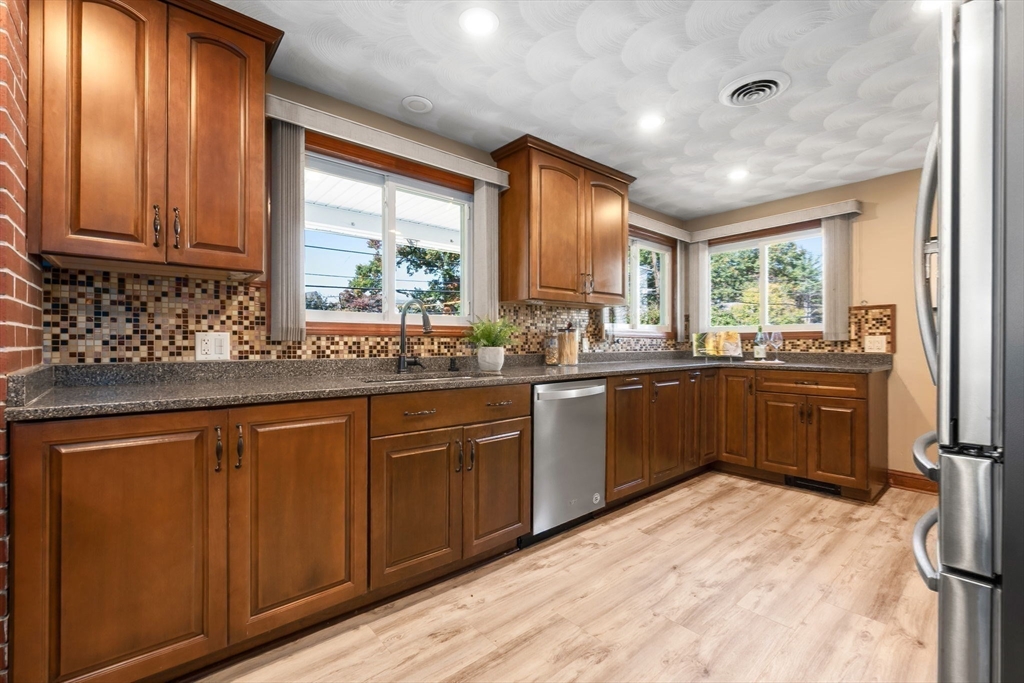97 Oak Street Stoneham, MA 02180 - Photo 21 of 42 a kitchen with stainless steel appliances kitchen island granite countertop a sink window and cabinets