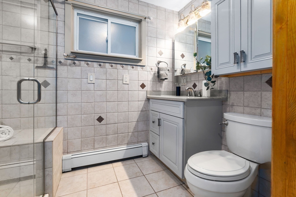 97 Oak Street Stoneham, MA 02180 - Photo 27 of 42 a bathroom with a granite countertop toilet sink and mirror