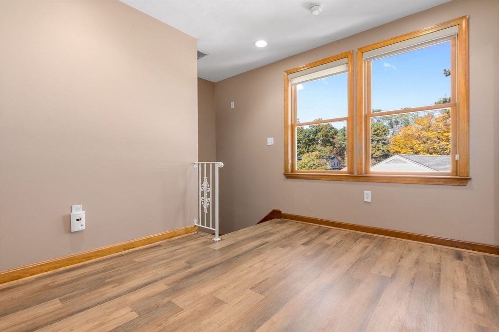 97 Oak Street Stoneham, MA 02180 - Photo 29 of 42 a view of an empty room with wooden floor and a window