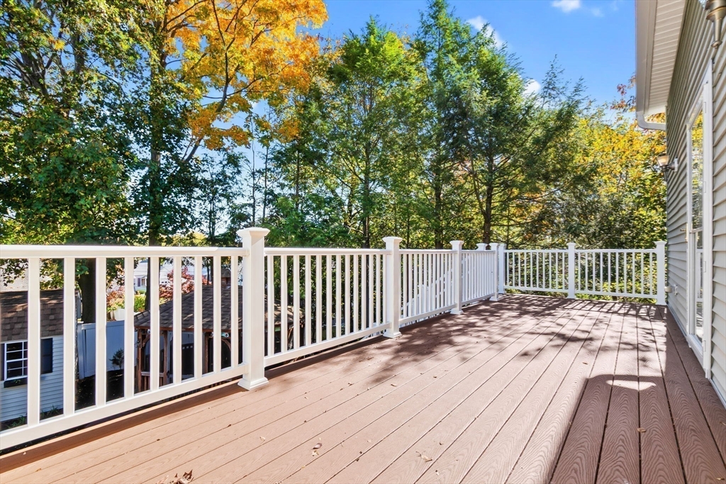 97 Oak Street Stoneham, MA 02180 - Photo 40 of 42 a balcony with wooden floor and trees in the background