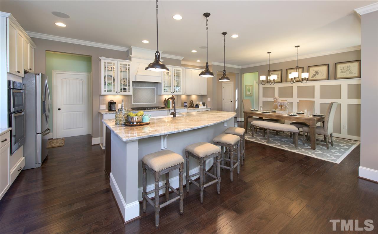 2005 Ernesto Lane Raleigh, NC 27603 - Photo 4 of 11 a dining room with stainless steel appliances kitchen island granite countertop a table chairs and a refrigerator