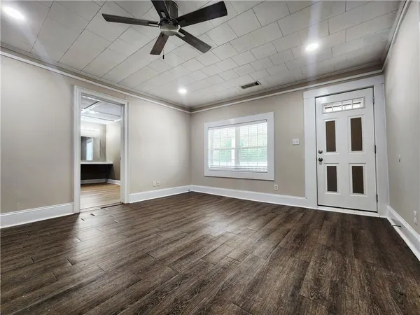 an empty room with wooden floor and windows