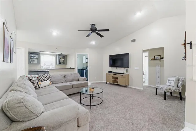 a bedroom with a bed a couch and a flat tv screen on the dresser