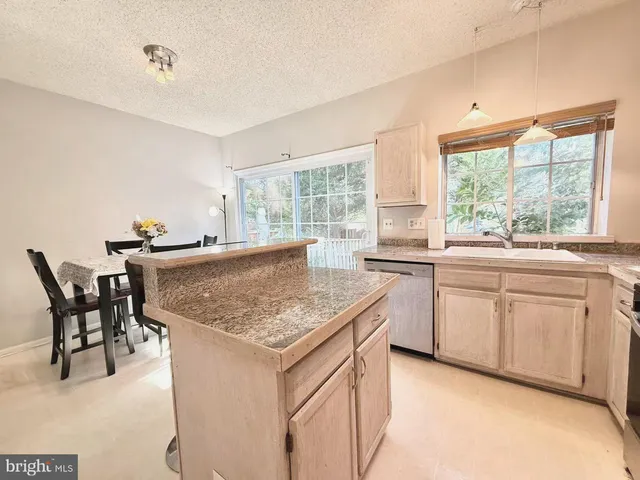 a kitchen with white cabinets and sink