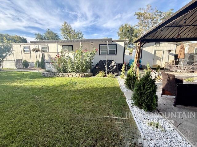 111 East Simplot Boulevard Caldwell, ID 83605 - Photo 2 of 17 Expansive lawn area with a stone-edged planter and established shrubbery