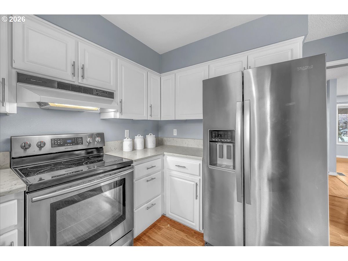 2775 Southwest 182nd Avenue Beaverton, OR 97003 - Photo 11 of 35 a kitchen with stainless steel appliances granite countertop a refrigerator stove and white cabinets