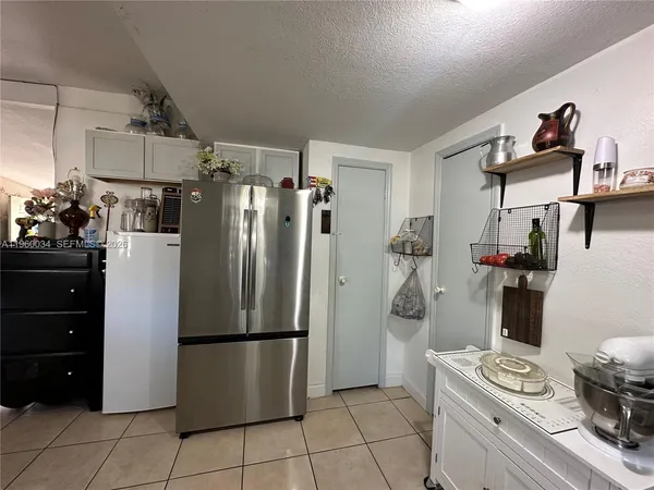 a living room with furniture and a refrigerator
