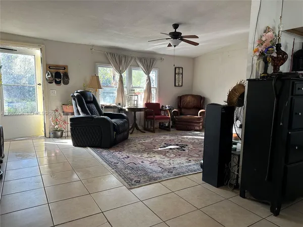 a living room with furniture a window and a flat screen tv