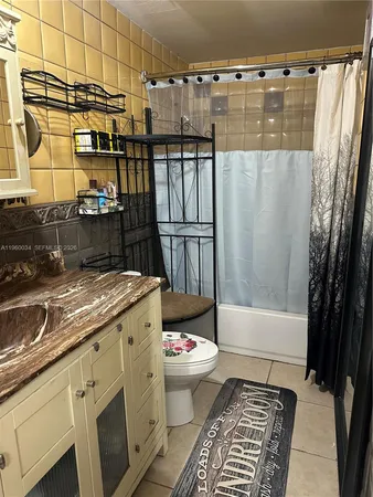 a bathroom with a granite countertop sink and a shower