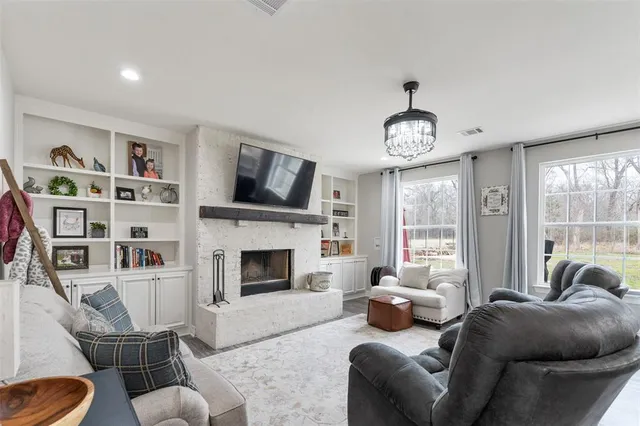 a living room with furniture a flat screen tv and a fireplace