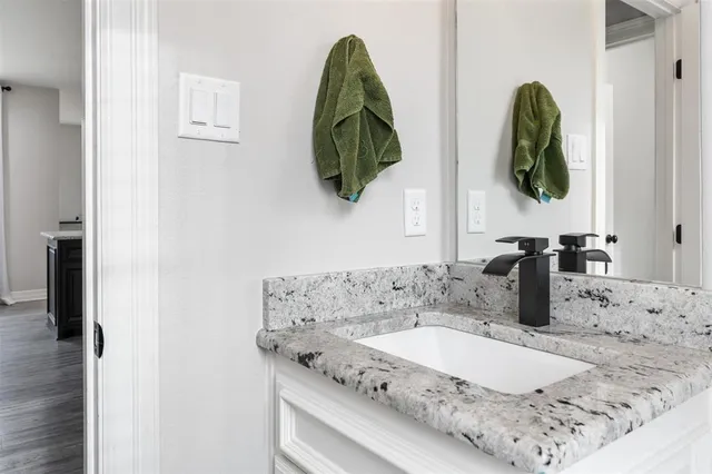 a bathroom with a granite countertop sink and mirror
