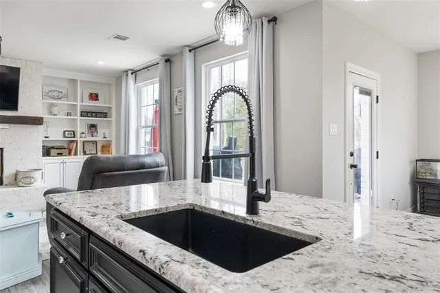 a kitchen with a stove a faucet and a dining table view