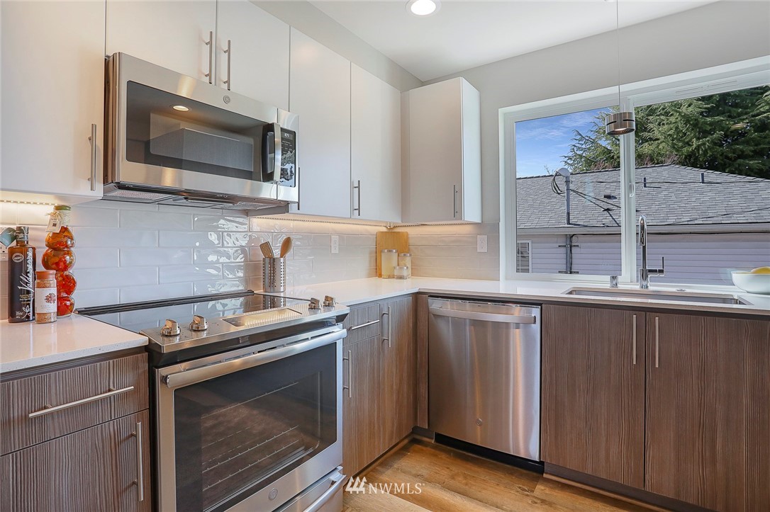 6241 8th Avenue Northwest Seattle, WA 98107 - Photo 11 of 27 a kitchen with stainless steel appliances a stove microwave and sink