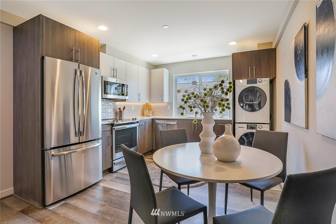 6241 8th Avenue Northwest Seattle, WA 98107 - Photo 10 of 27 a kitchen with stainless steel appliances granite countertop a dining table chairs and refrigerator