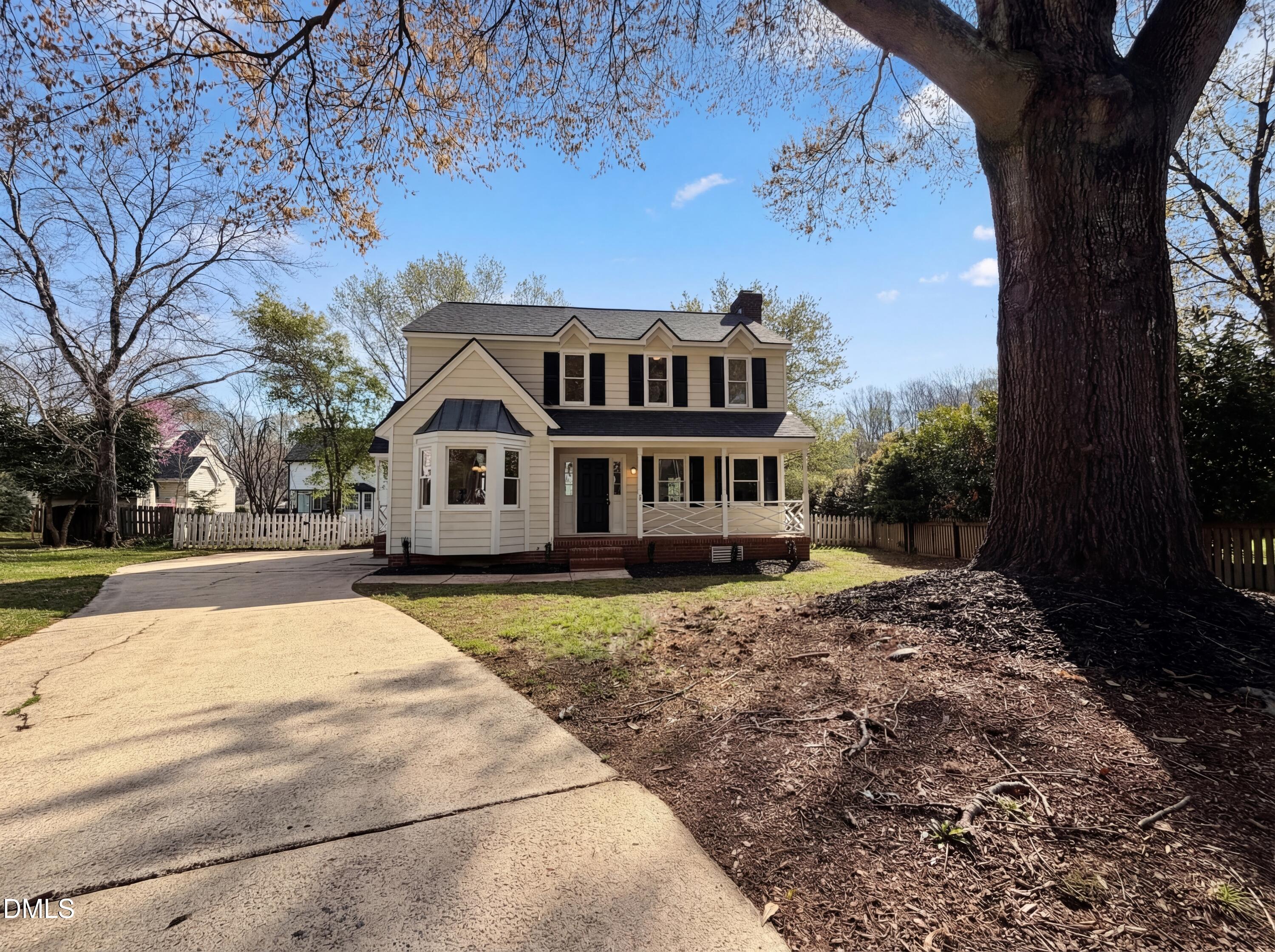 a front view of a house with a yard and trees