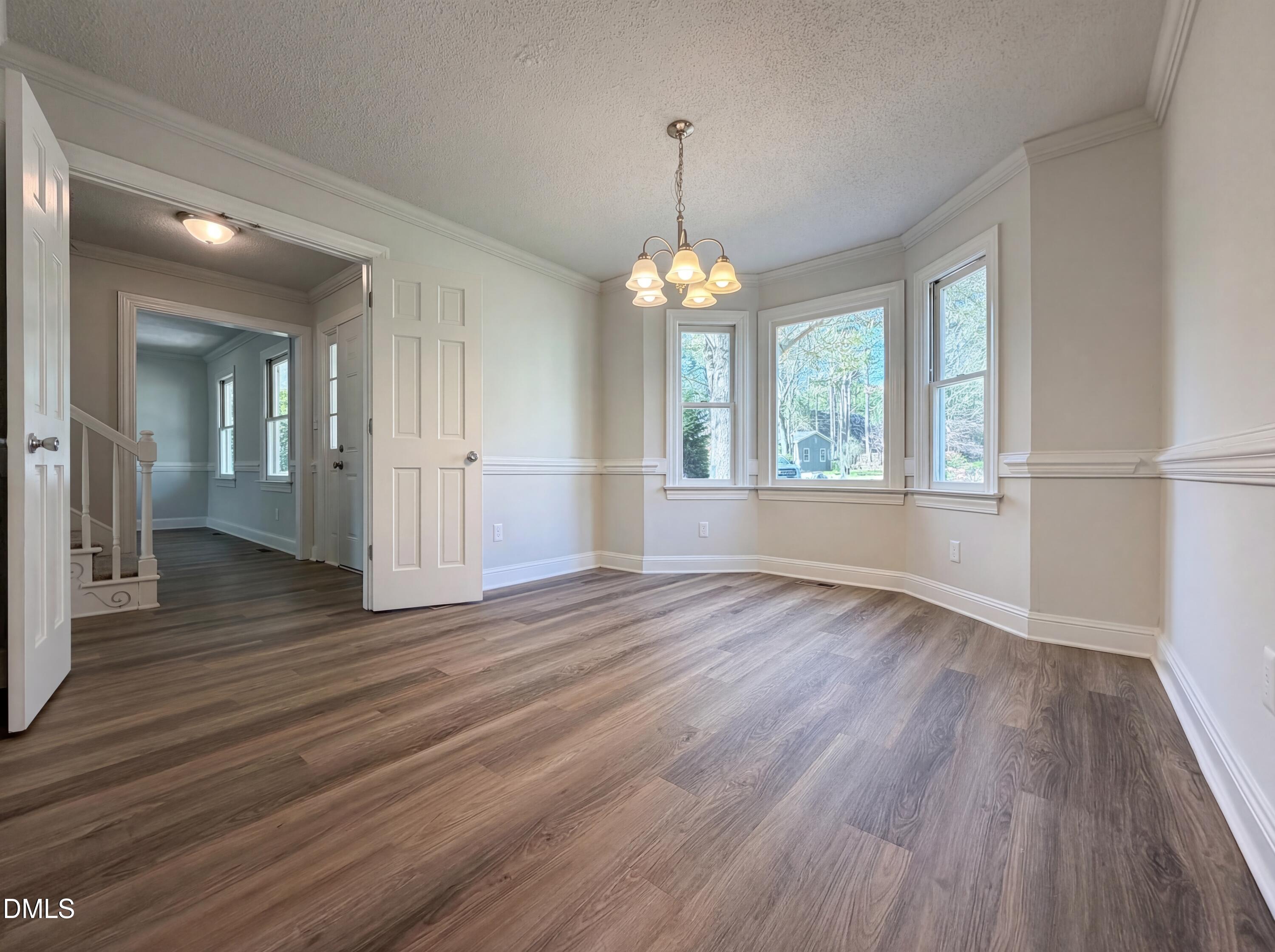 8612 Clovehitch Court Raleigh, NC 27615 - Photo 12 of 25 an empty room with wooden floor and windows