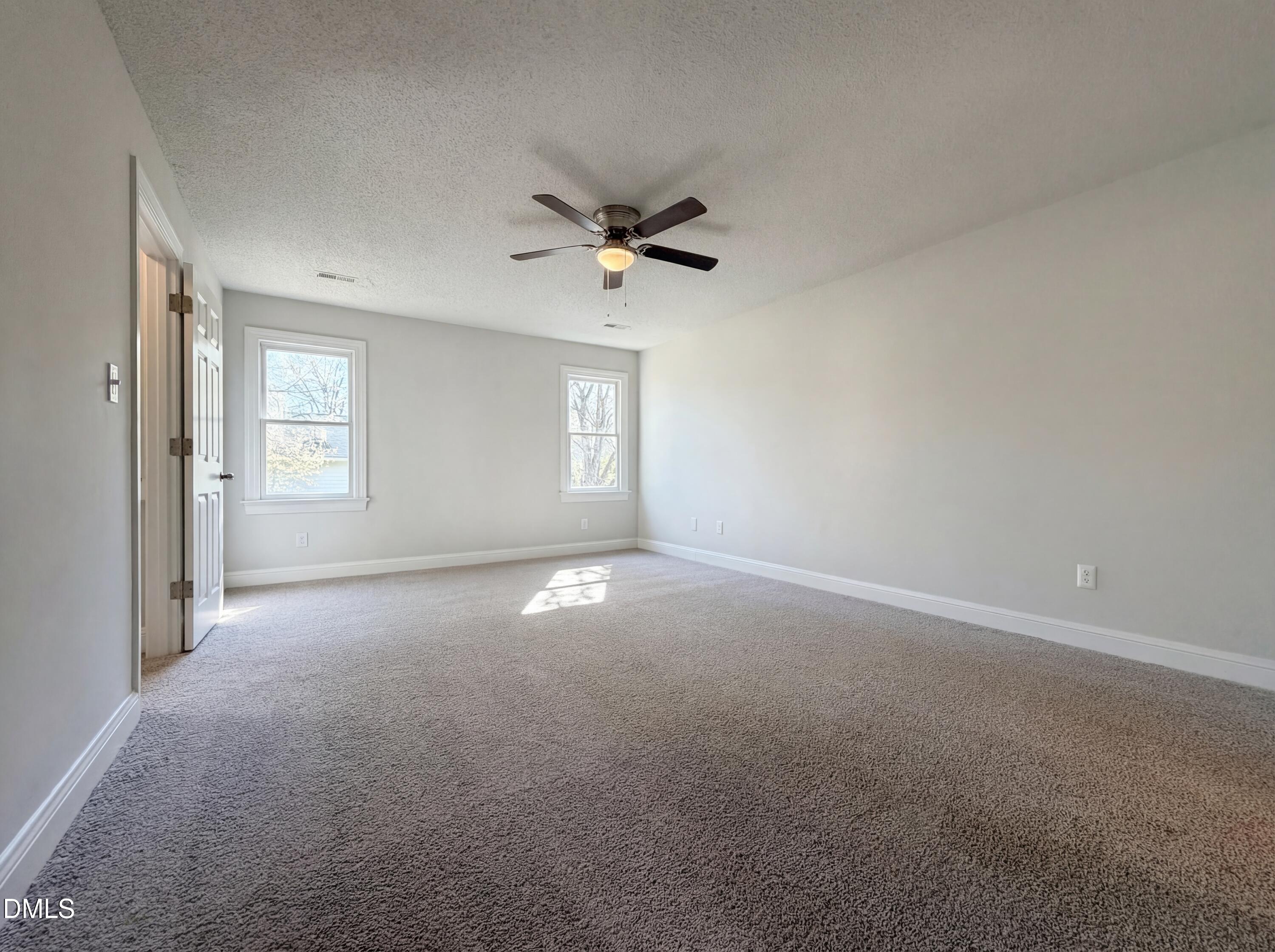 8612 Clovehitch Court Raleigh, NC 27615 - Photo 17 of 25 an empty room with a window and a ceiling fan