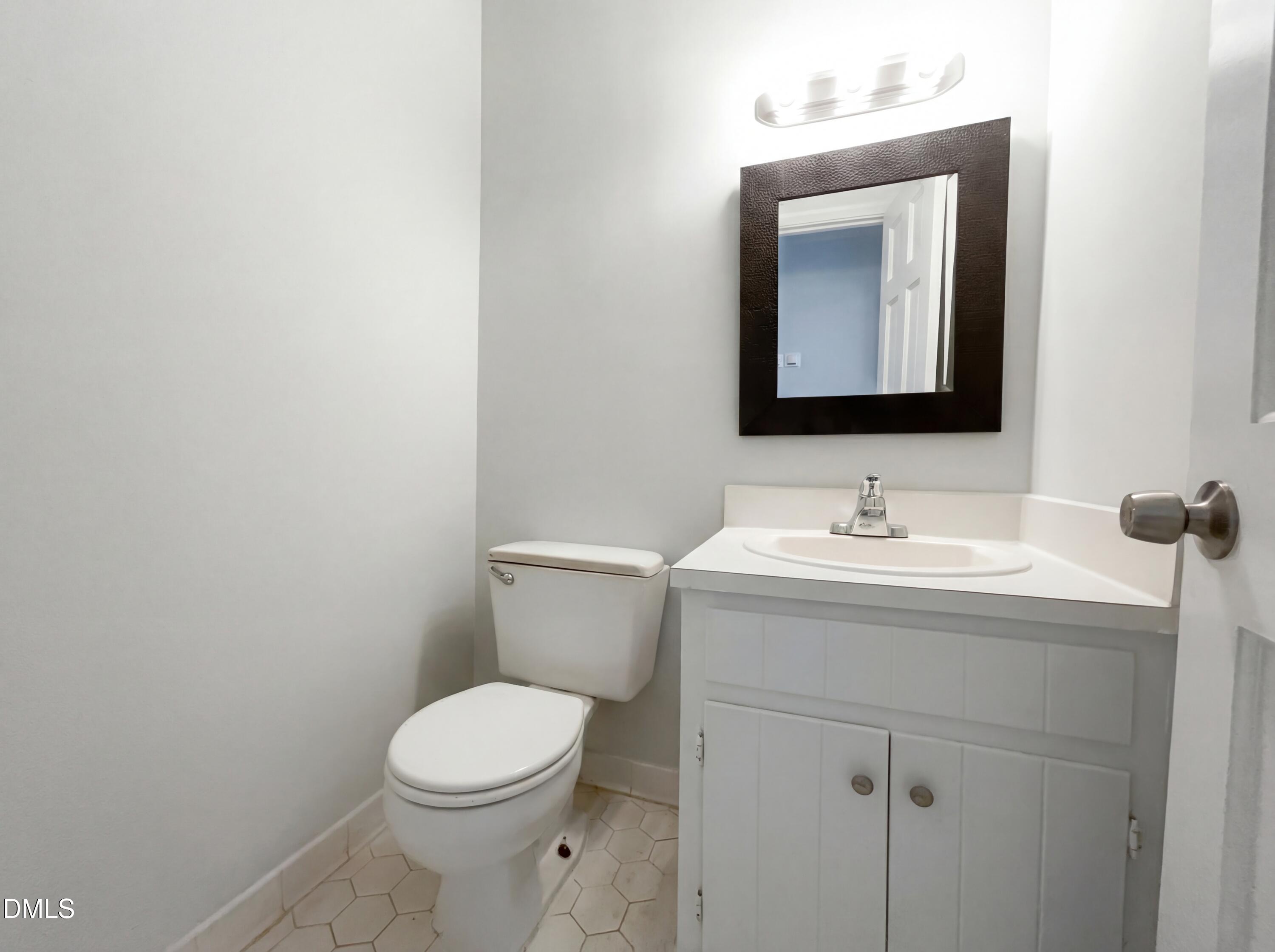 8612 Clovehitch Court Raleigh, NC 27615 - Photo 18 of 21 a bathroom with a toilet sink and mirror