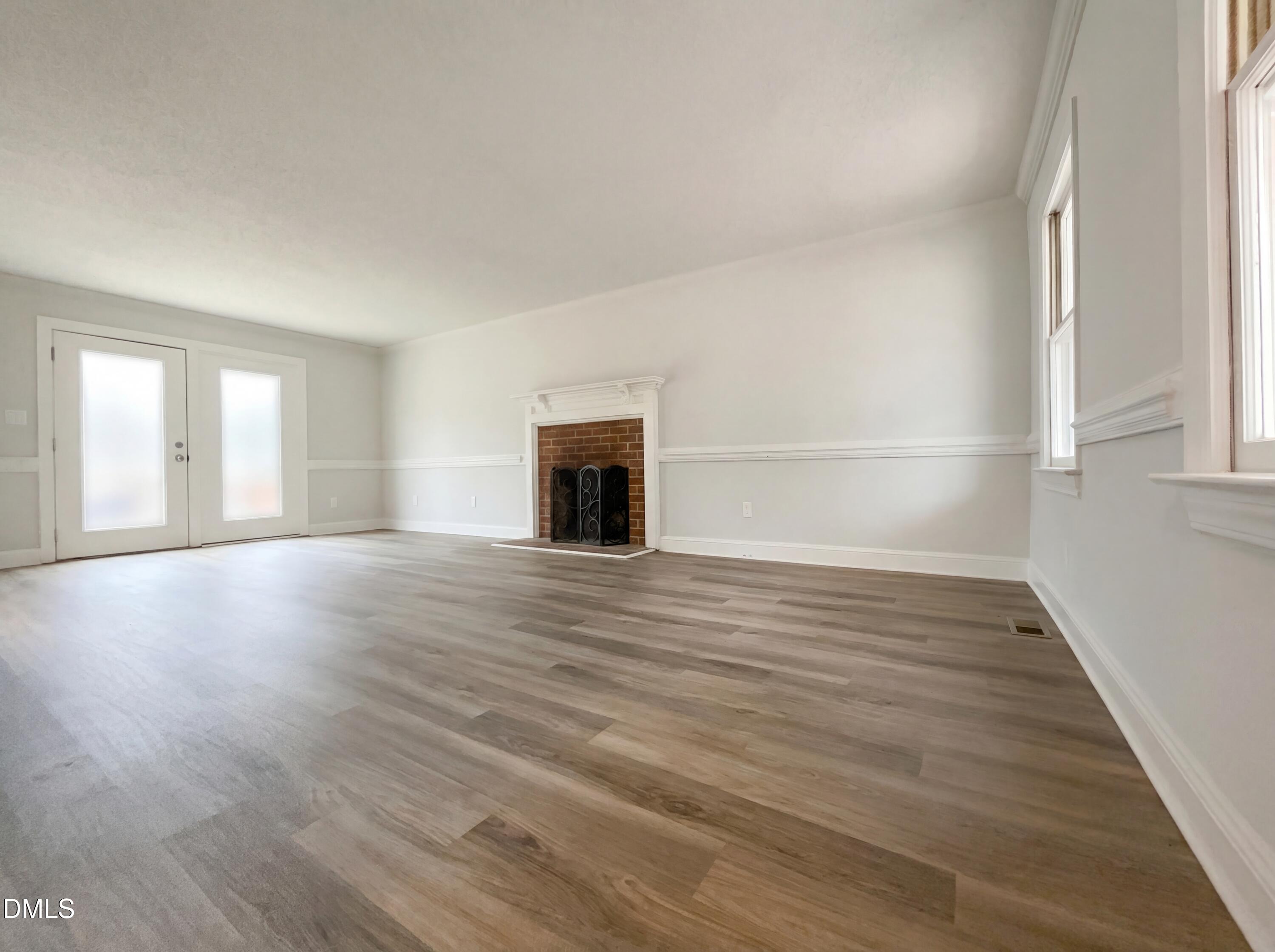 8612 Clovehitch Court Raleigh, NC 27615 - Photo 4 of 21 a view of empty room with wooden floor and fireplace