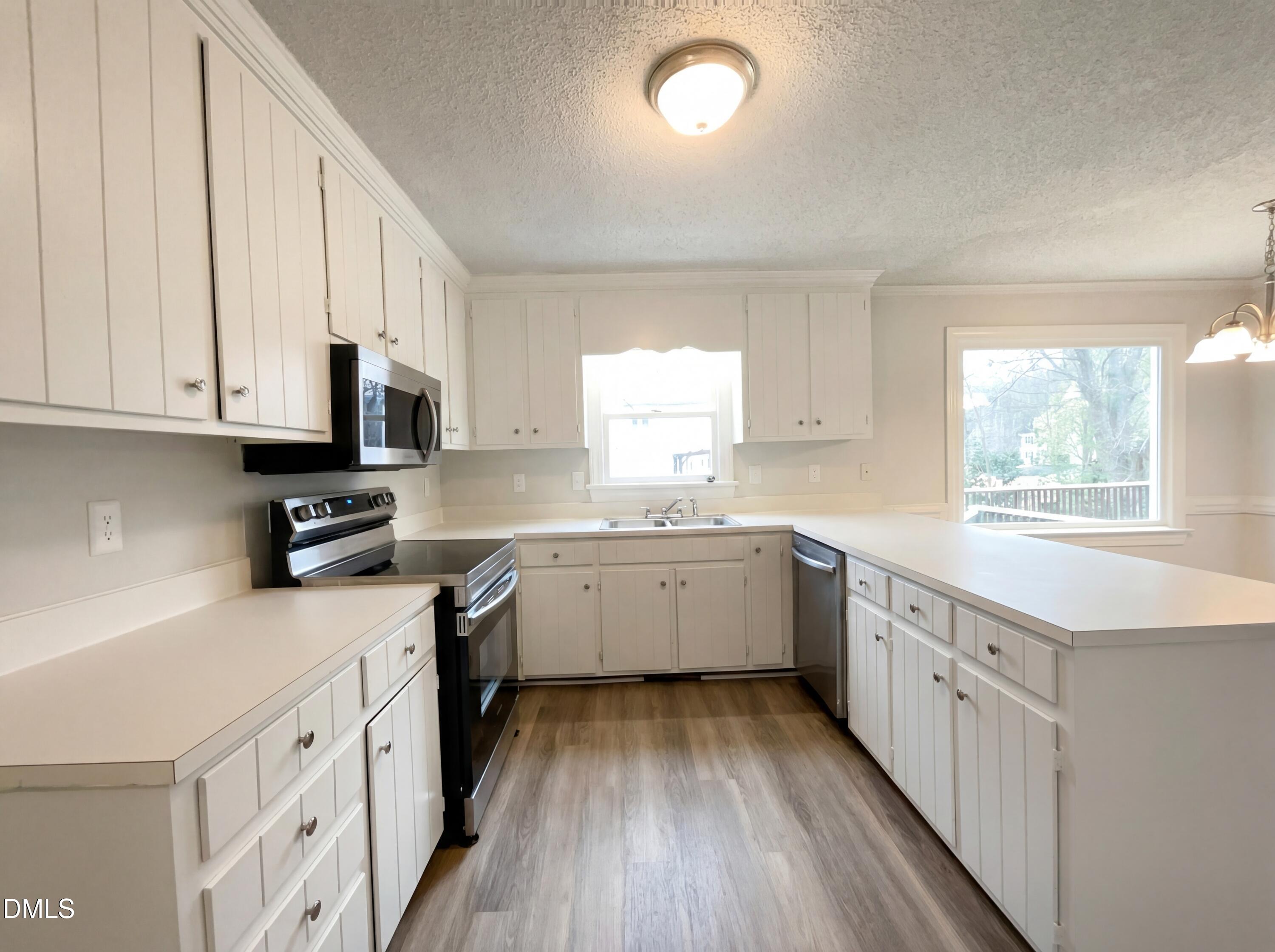 8612 Clovehitch Court Raleigh, NC 27615 - Photo 5 of 21 a kitchen with granite countertop white cabinets white stainless steel appliances a sink and window