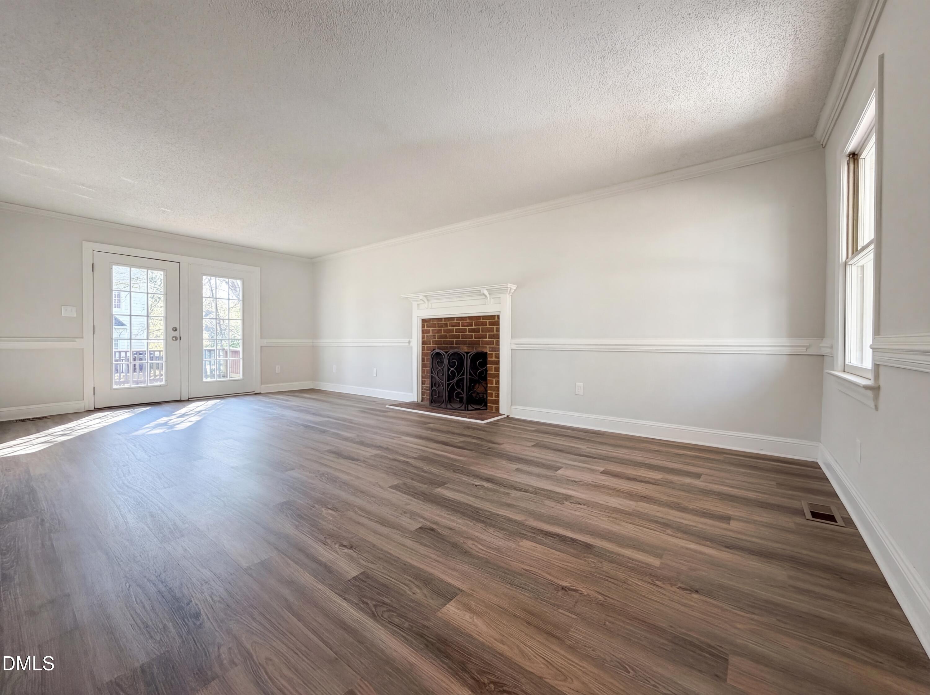 8612 Clovehitch Court Raleigh, NC 27615 - Photo 6 of 25 an empty room with wooden floor and windows