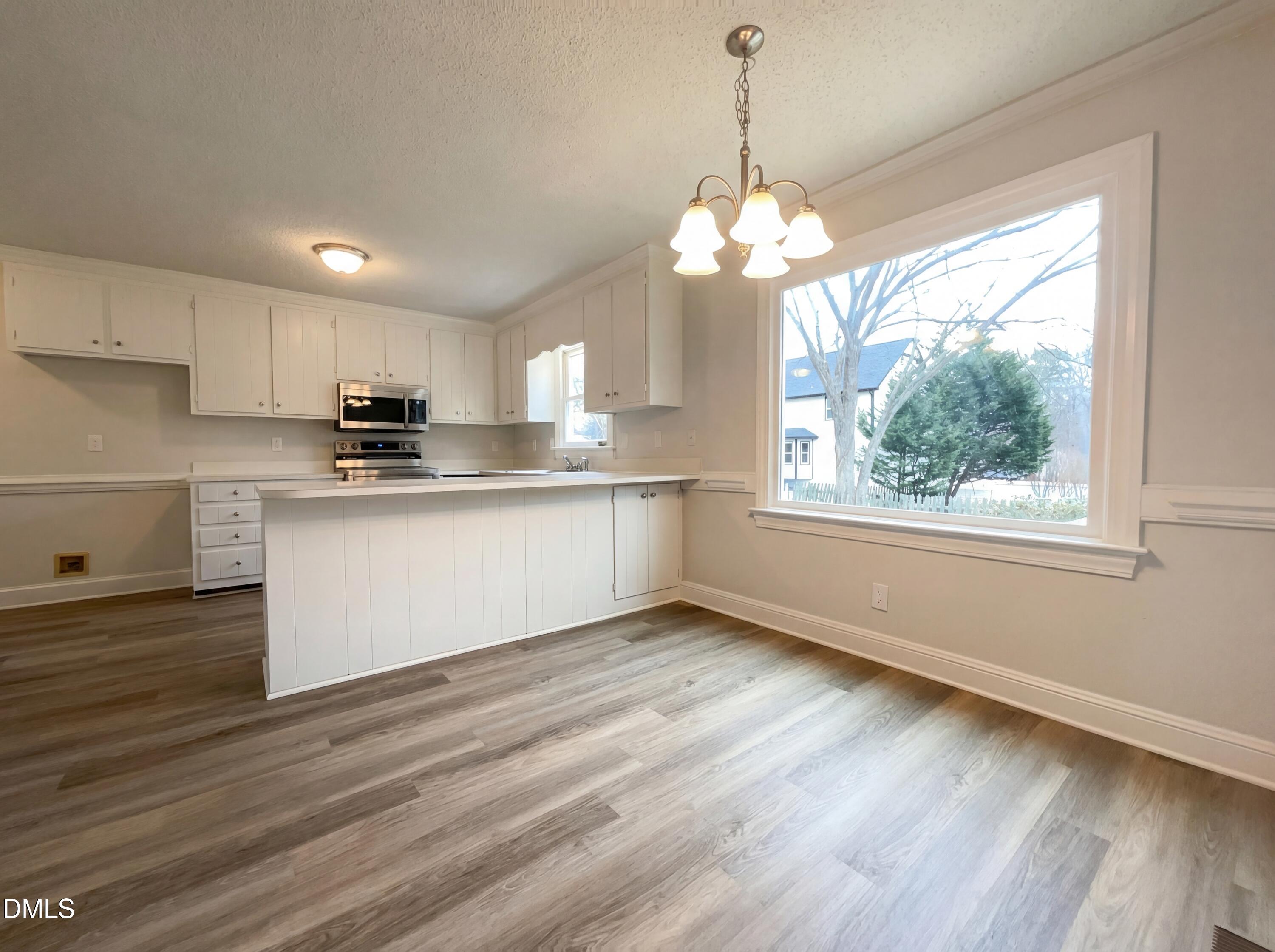8612 Clovehitch Court Raleigh, NC 27615 - Photo 7 of 21 a kitchen with stainless steel appliances granite countertop a stove a sink dishwasher a refrigerator and white cabinets with wooden floor