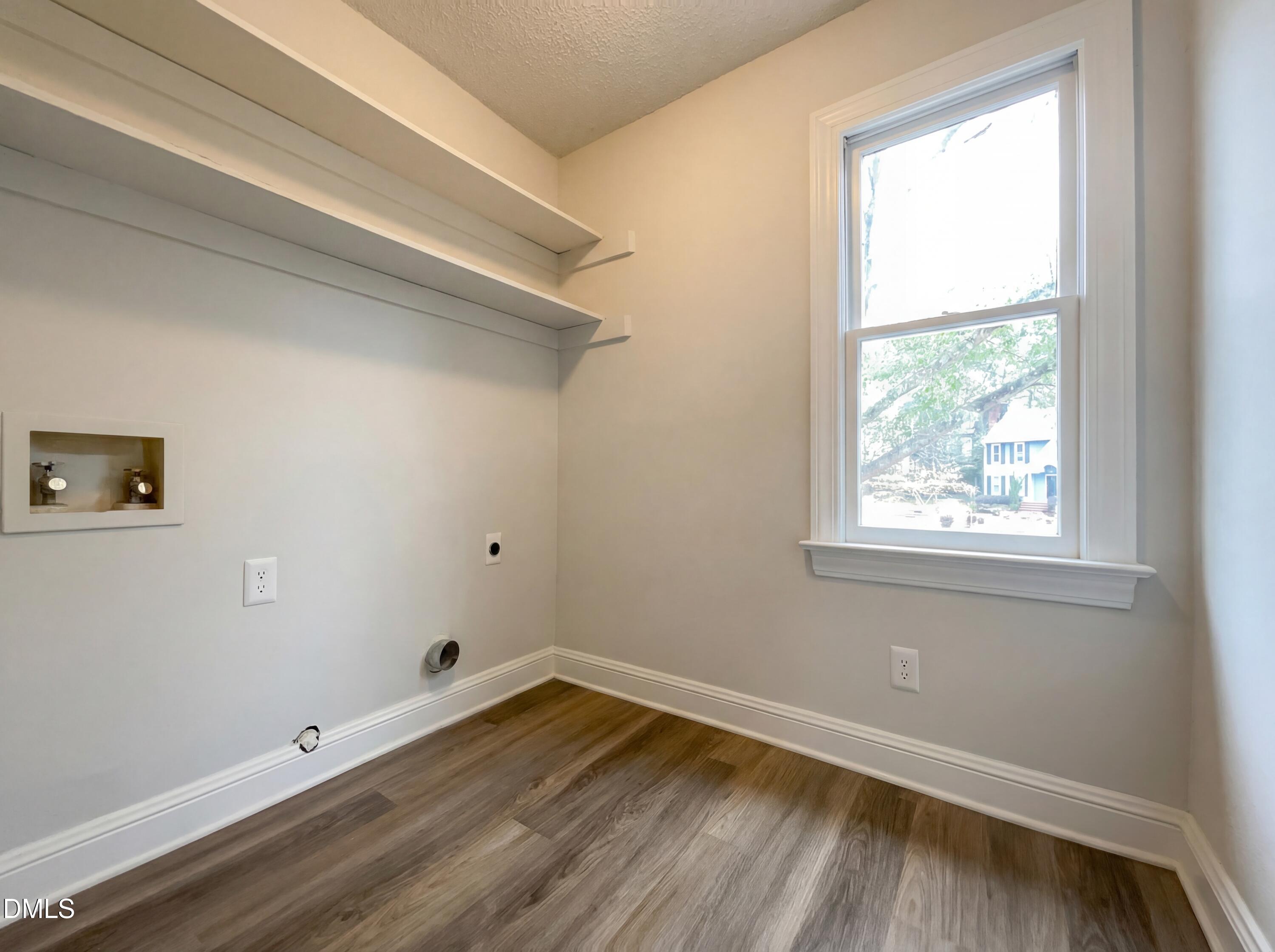 8612 Clovehitch Court Raleigh, NC 27615 - Photo 8 of 21 a view of an empty room with wooden floor and a window