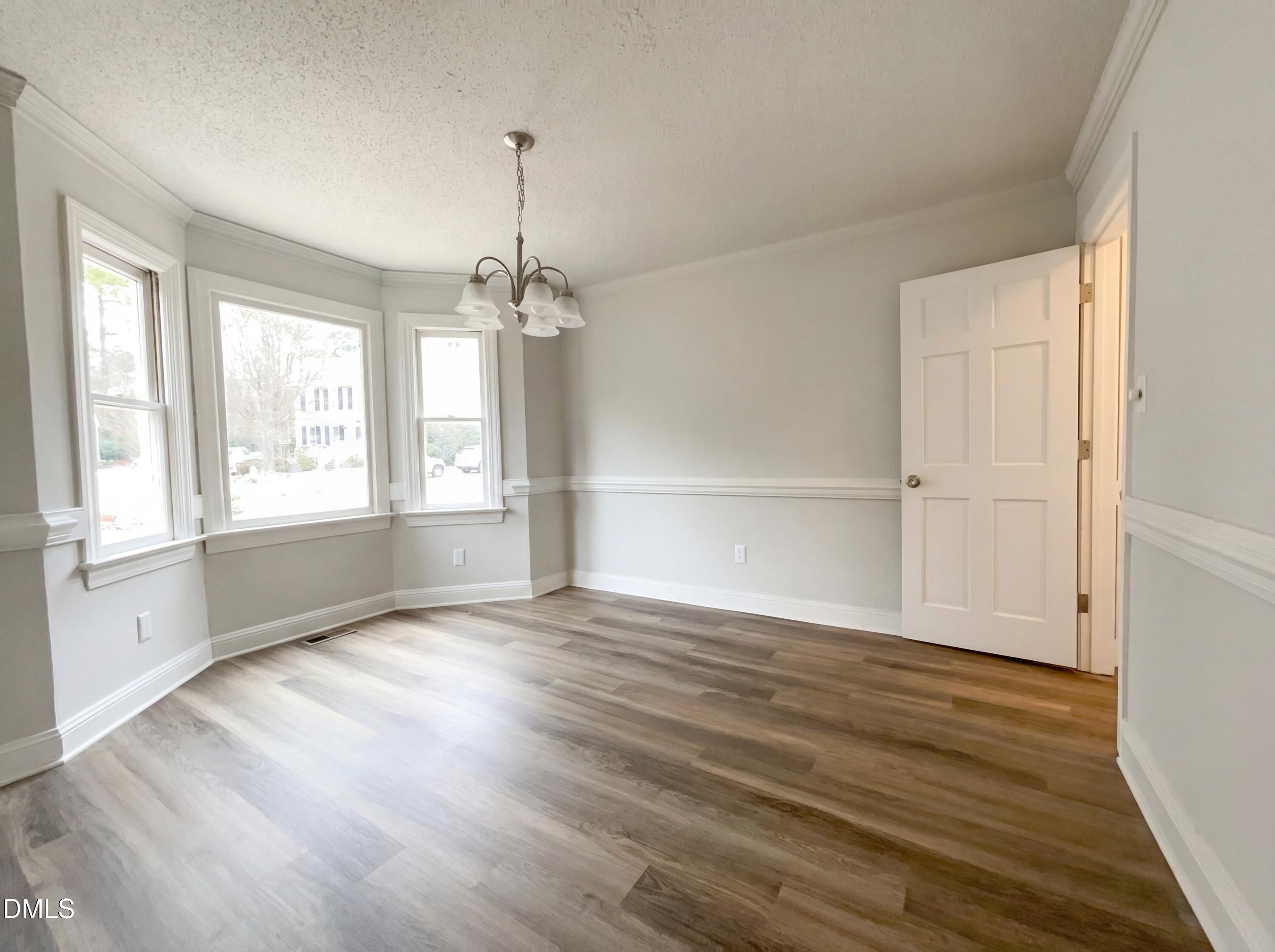 8612 Clovehitch Court Raleigh, NC 27615 - Photo 9 of 21 a view of an empty room with wooden floor and a window