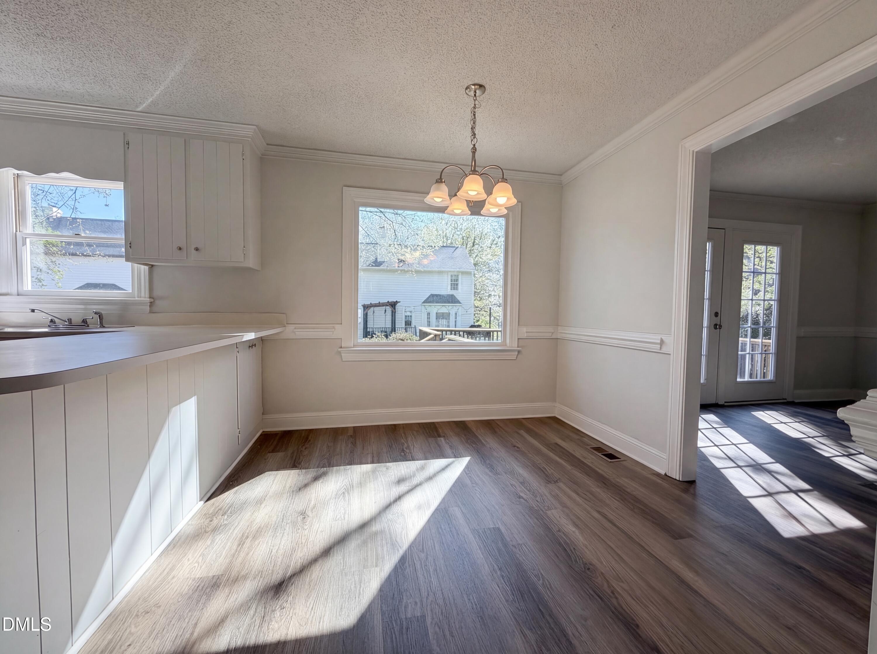 8612 Clovehitch Court Raleigh, NC 27615 - Photo 10 of 25 a view of kitchen with window ceiling fan and wooden floor