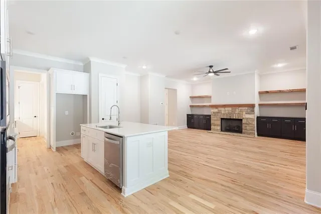 a large kitchen with kitchen island sink stove and white cabinets