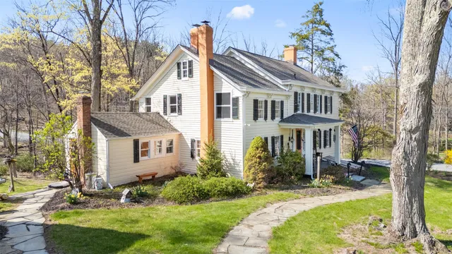 a living room with stainless steel appliances furniture a rug a fireplace and a window