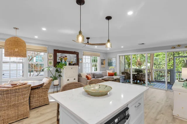 a view of a dining room and livingroom with furniture large windows a chandelier