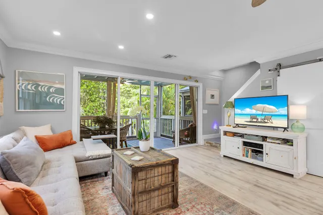 a living room with furniture a flat screen tv and a large window