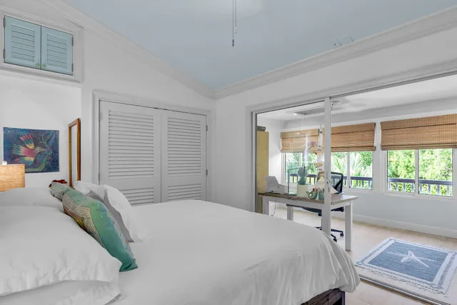 a bedroom with a bed and a large window