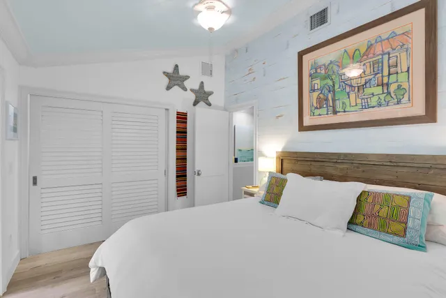 a bedroom with a bed and a painting on the wall