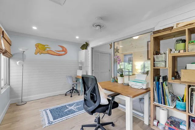a view of a workspace with furniture and a window
