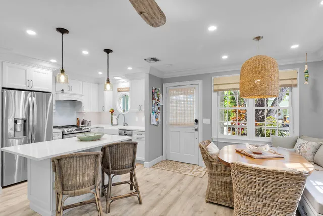 a kitchen with stainless steel appliances granite countertop a stove a kitchen island a dining table and chairs