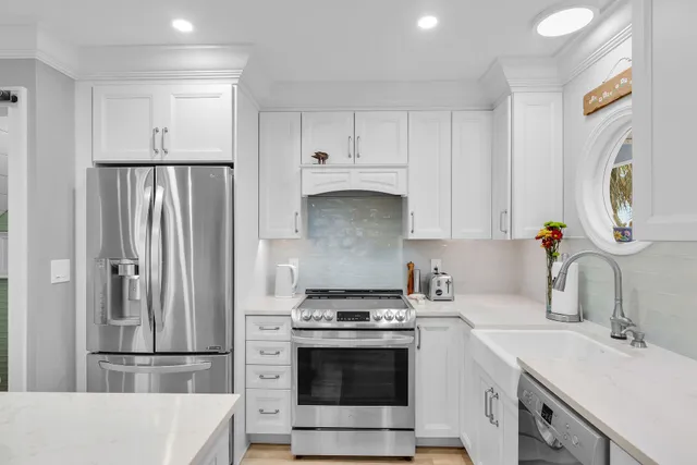 a kitchen with stainless steel appliances a stove a sink and a refrigerator