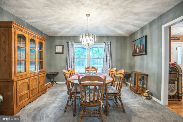 a kitchen with stainless steel appliances granite countertop a refrigerator a sink dishwasher a stove and white countertops with wooden floor