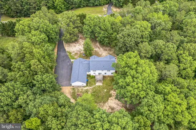 a open kitchen with stainless steel appliances granite countertop a stove top oven a refrigerator a dining table and chairs with wooden floor