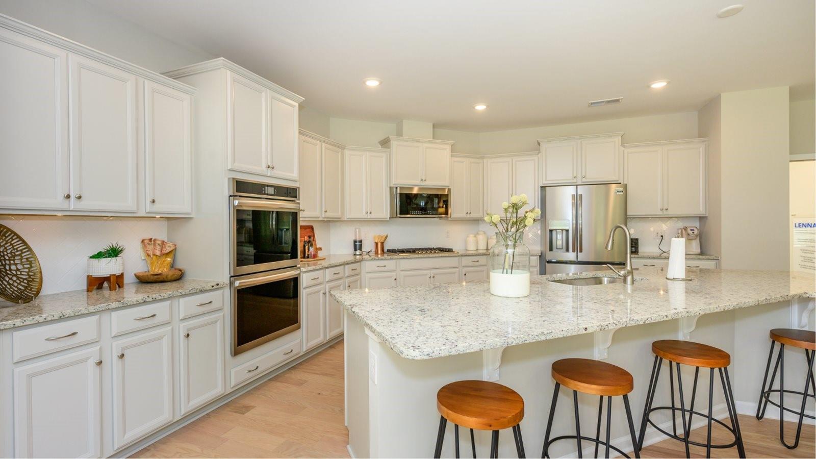 a kitchen with stainless steel appliances granite countertop a table chairs stove microwave and cabinets