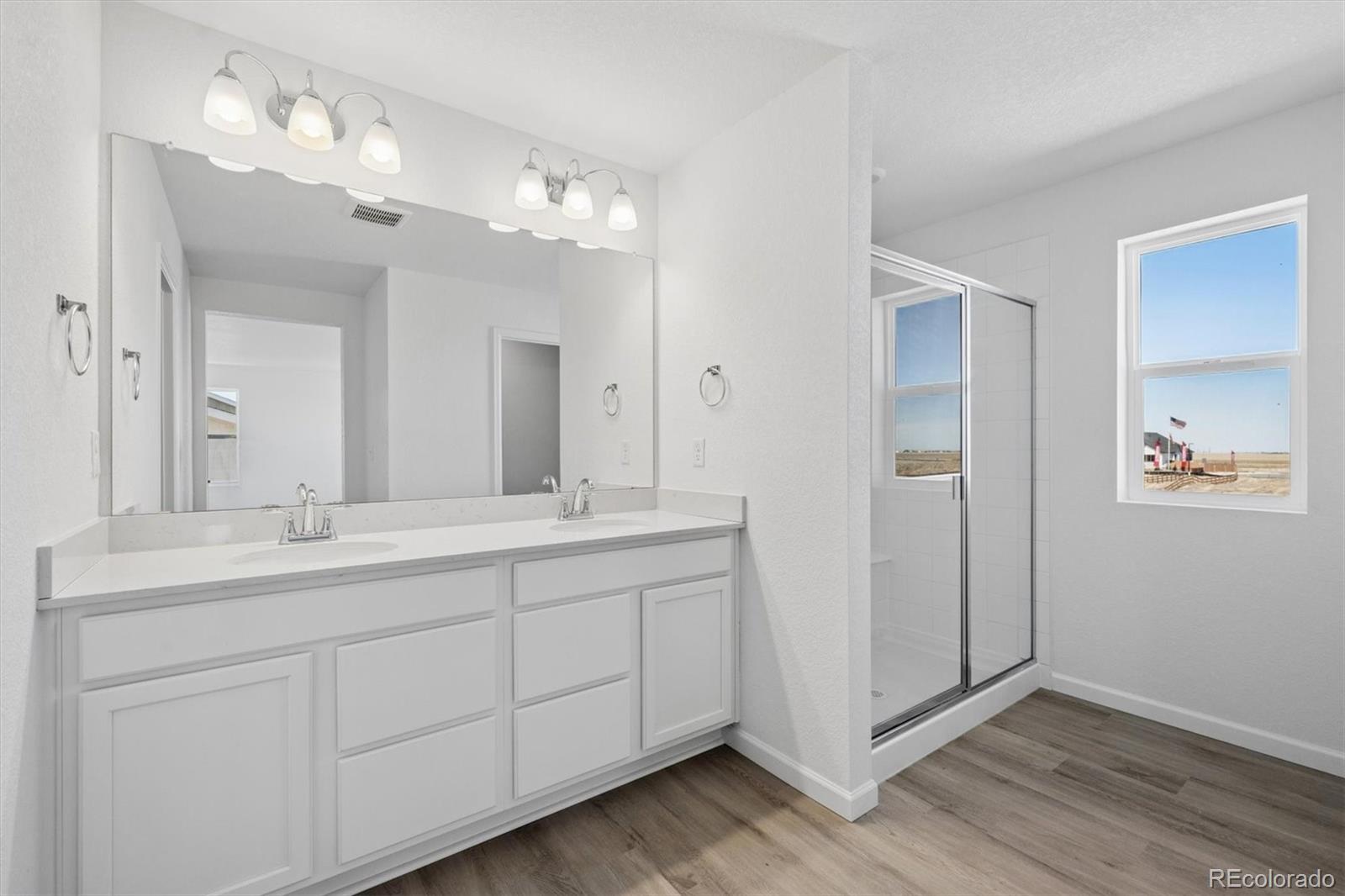 45935 Gentry Avenue Bennett, CO 80102 - Photo 13 of 22 a bathroom with a double vanity sink and mirror