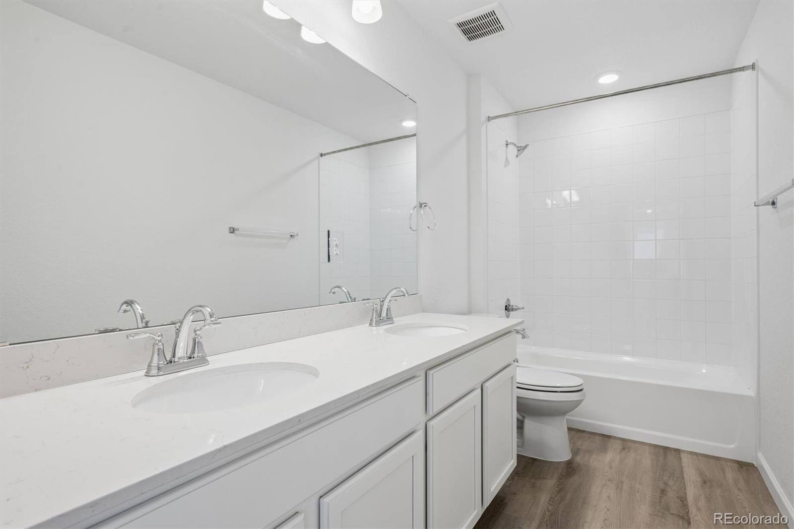 45935 Gentry Avenue Bennett, CO 80102 - Photo 16 of 22 a bathroom with a granite countertop sink a toilet and shower