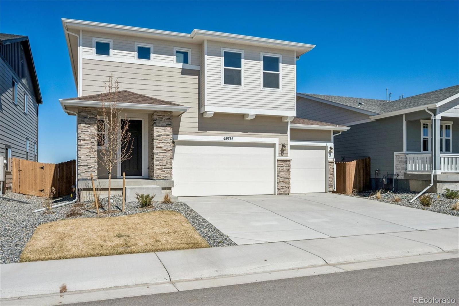 45935 Gentry Avenue Bennett, CO 80102 - Photo 2 of 22 a view of a white house with large windows